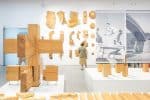 Besucher betrachtet Holzexponate im hell erleuchteten Raum des Manggha Museums für japanische Kunst und Technik.