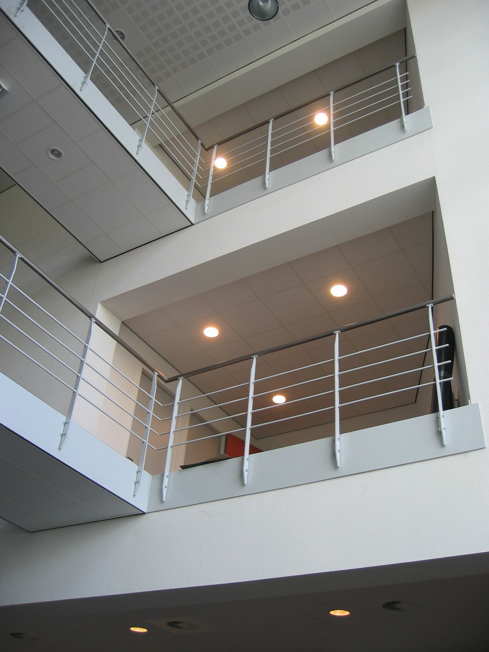 Modern construction project: interior of a building with minimalist open balcony, steel railing and precise engineering.