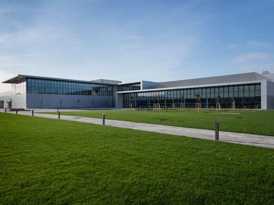 Moderne Büro- und Fabrikgebäude von Jaguar Land Rover mit großer Glasfront und gepflegter Grünfläche im Vordergrund.